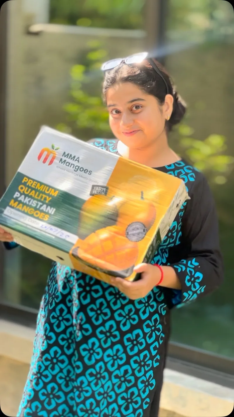 Happy female customer holding MMA Mangoes premium box - satisfied customer Pakistani mangoes delivery